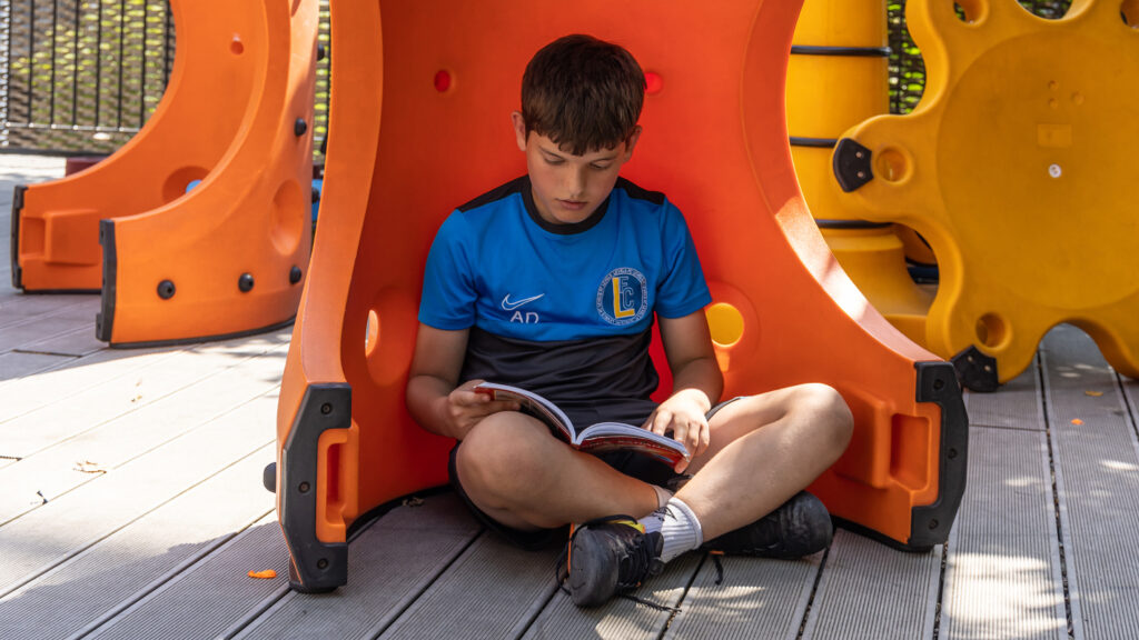 Kids reading in playground King's Cross Academy Primary School