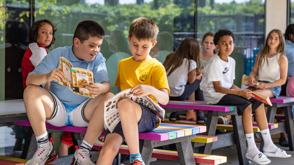 Kids reading in playground King's Cross Academy Primary School