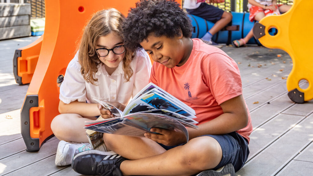 Kids reading in playground King's Cross Academy Primary School
