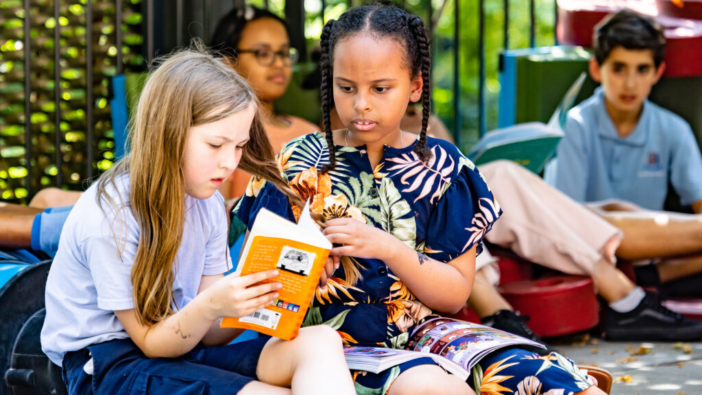 Kids reading in playground King's Cross Academy Primary School